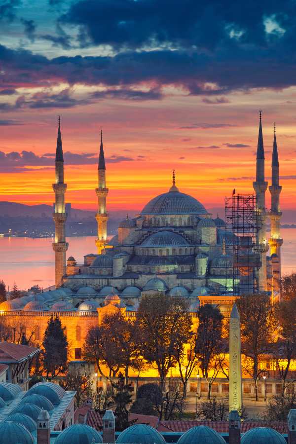 Moschea Blu al tramonto: Istanbul in tutto il suo splendore Vista al tramonto della Moschea Blu di Istanbul con il Bosforo sullo sfondo.
