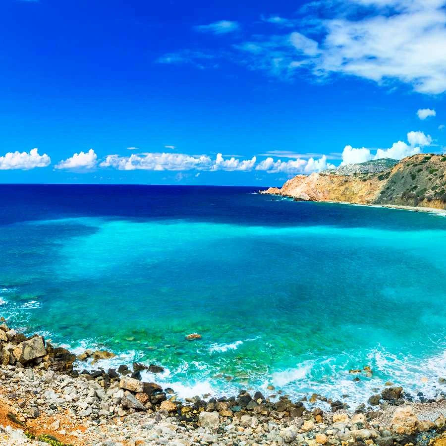 Spiaggia tranquilla a Karpathos con mare turchese e costa rocciosa