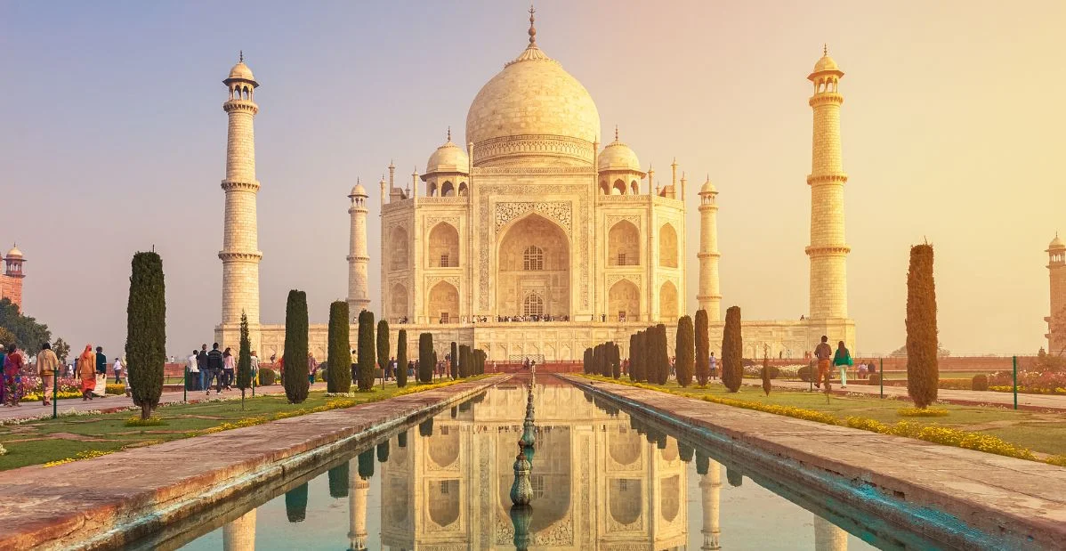 Il Taj Mahal al tramonto, con il suo riflesso nella piscina e giardini curati, Agra, India.