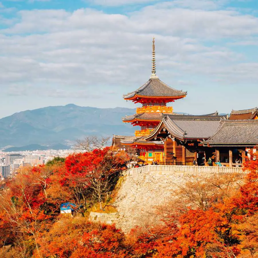 Il tempio Kiyomizudera di Kyoto circondato da alberi rossi durante il foliage autunnale.