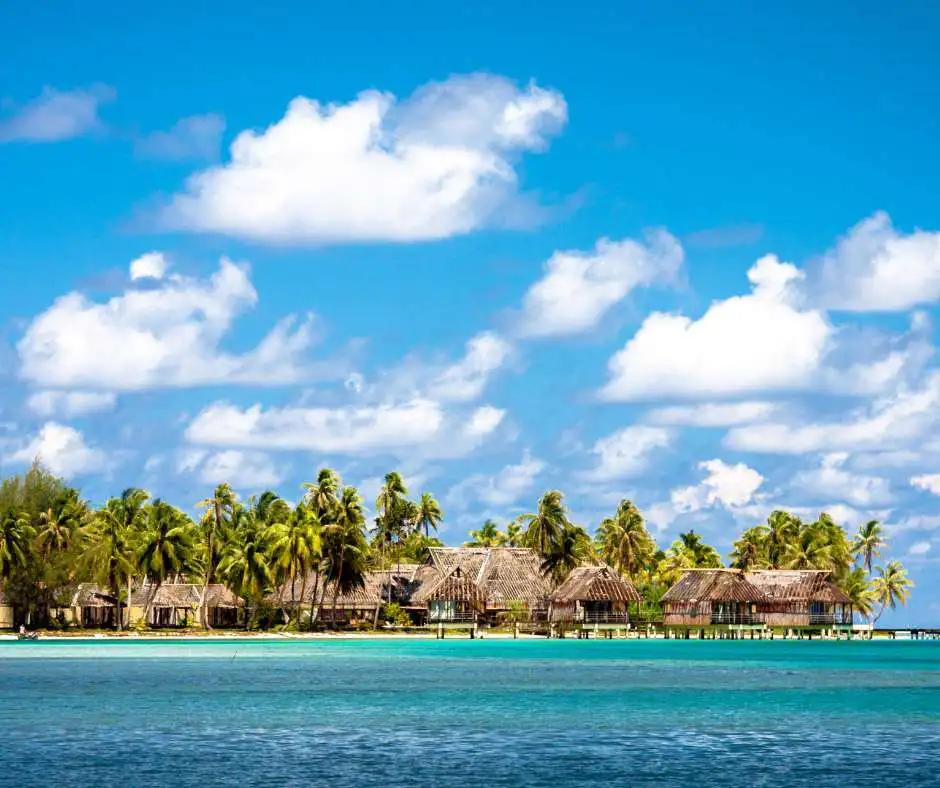 Offerta viaggio Polinesia Francese โ pacchetto vacanza con bungalow sulla laguna Bungalow tropicali sulla laguna con palme nella Polinesia Francese