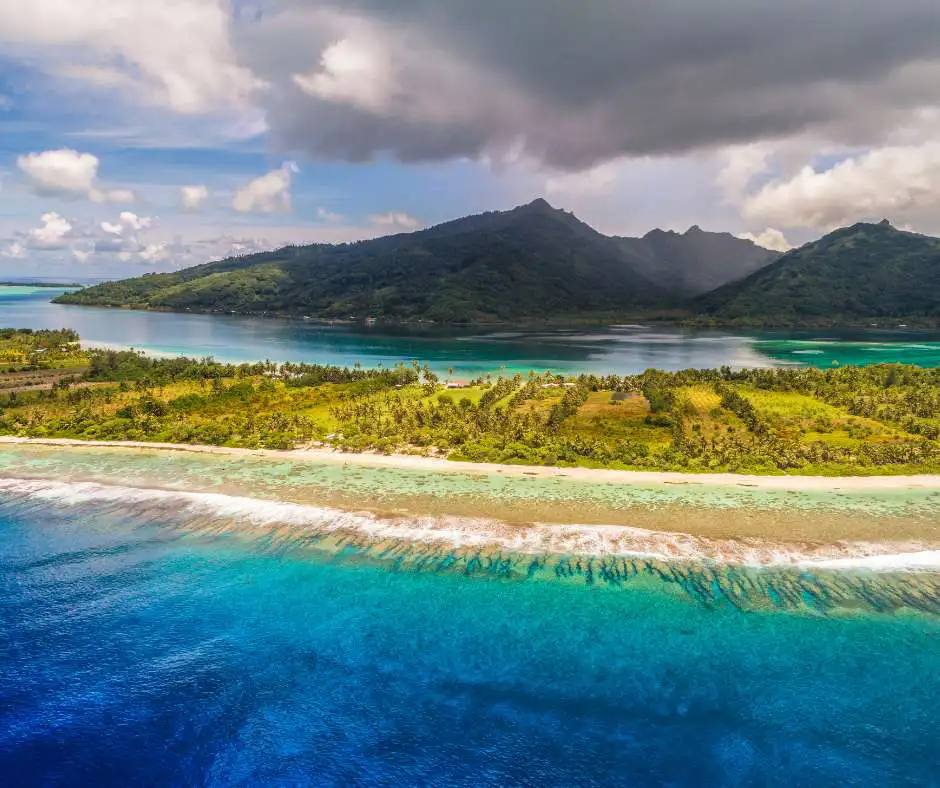 Offerta viaggio Polinesia Francese โ pacchetto vacanza tra isole e lagune tropicali Isola tropicale con montagne verdi e laguna turchese in Polinesia Francese