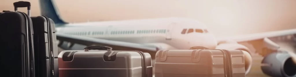 Valigie in aeroporto davanti a un aereo pronto alla partenza per un viaggio internazionale