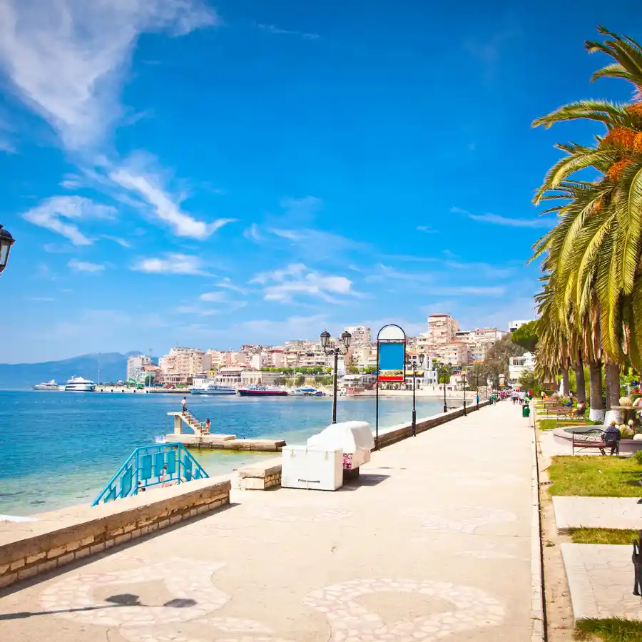 Lungomare di Saranda con palme, mare e città sullo sfondo lungo la costa dell’Albania