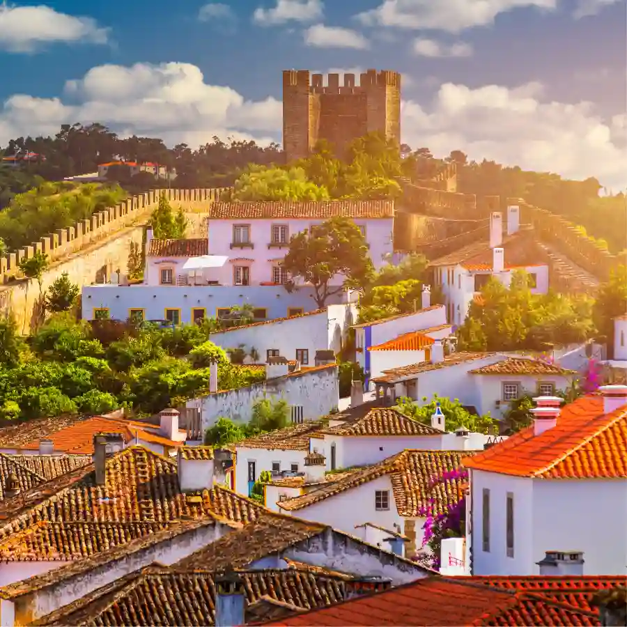 Borgo medievale di รbidos con case bianche, tetti rossi e mura storiche al tramonto in Portogallo
