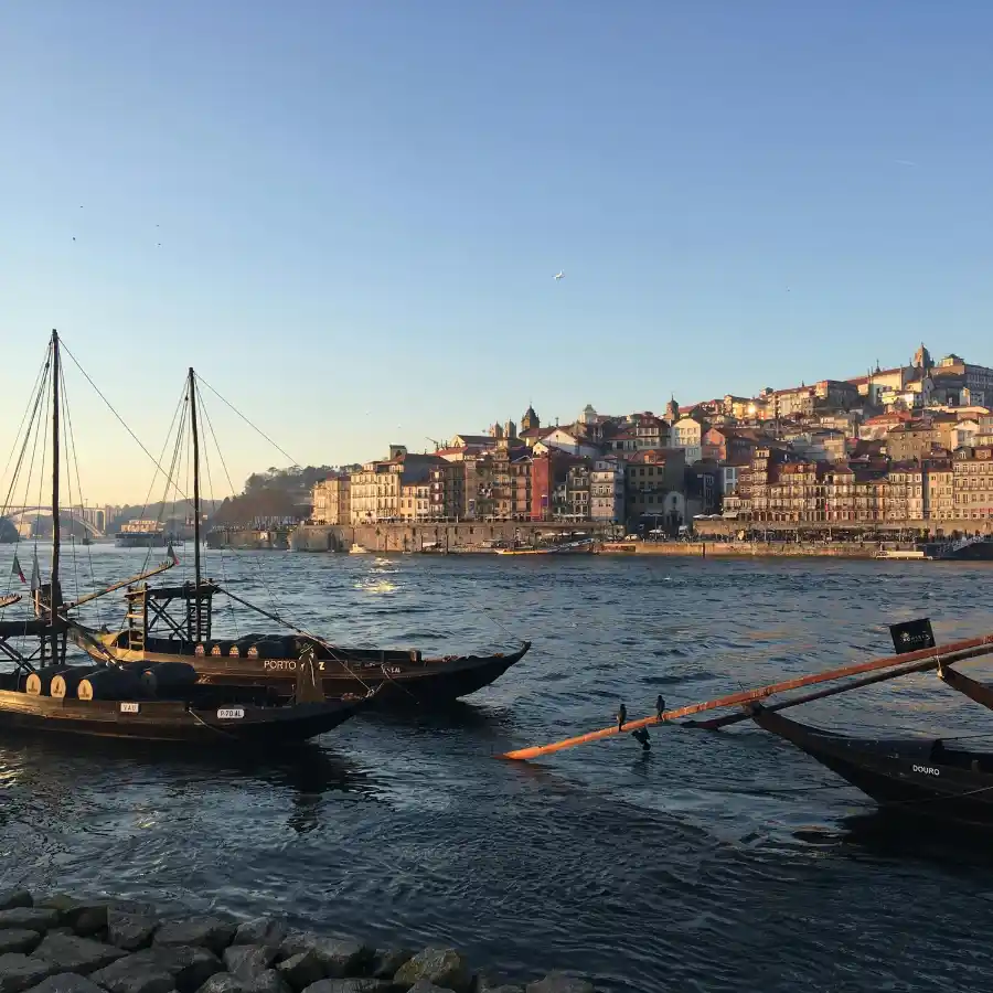 Barche sul fiume Douro con vista sul centro storico di Porto al tramonto