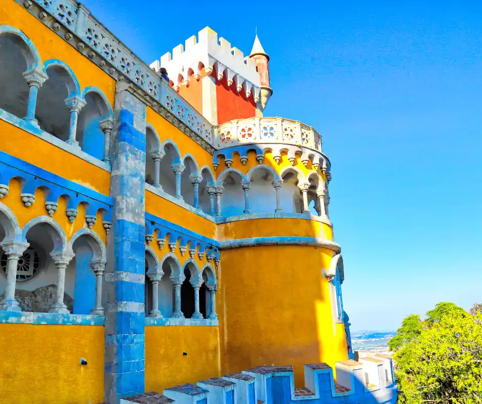 Offerta viaggio Portogallo Classico: pacchetto vacanza tra Sintra e palazzi iconici Dettaglio del Palazzo Pena a Sintra con archi decorati e colori vivaci su sfondo panoramico