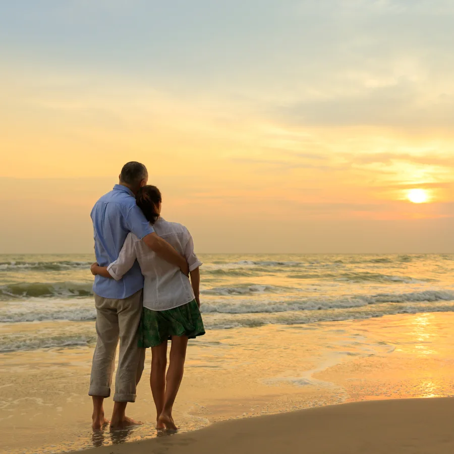 Coppia sulla spiaggia al tramonto durante un viaggio romantico sul mare