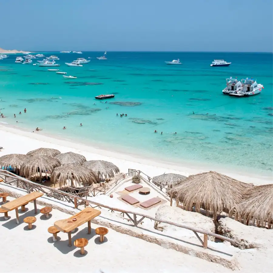 Spiaggia tropicale e mare turchese del Mar Rosso con resort e barche