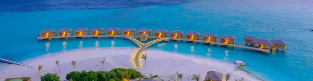 Ville overwater alle Maldive al tramonto con laguna turchese vista panoramica