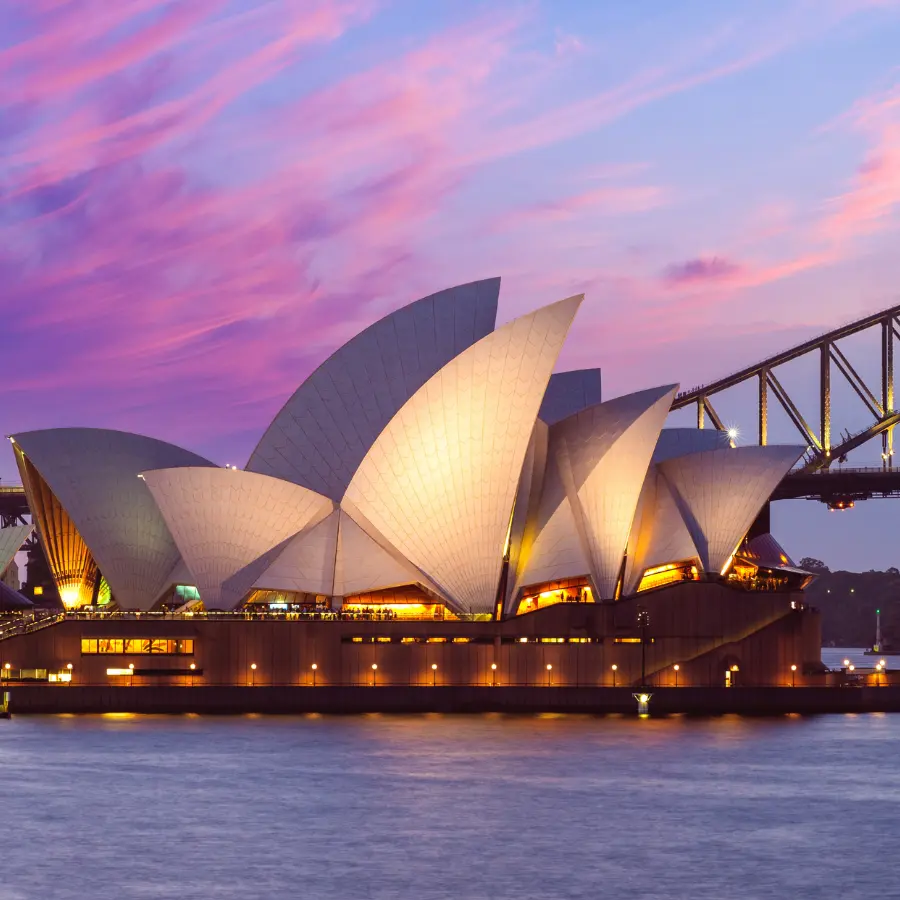 Sydney Opera House illuminata al tramonto con vista sul porto australiano
