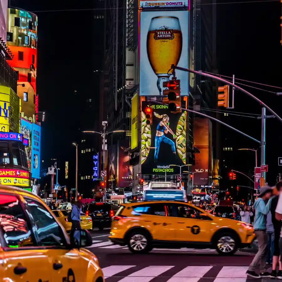 Times Square illuminata di notte con taxi e maxi schermi a New York