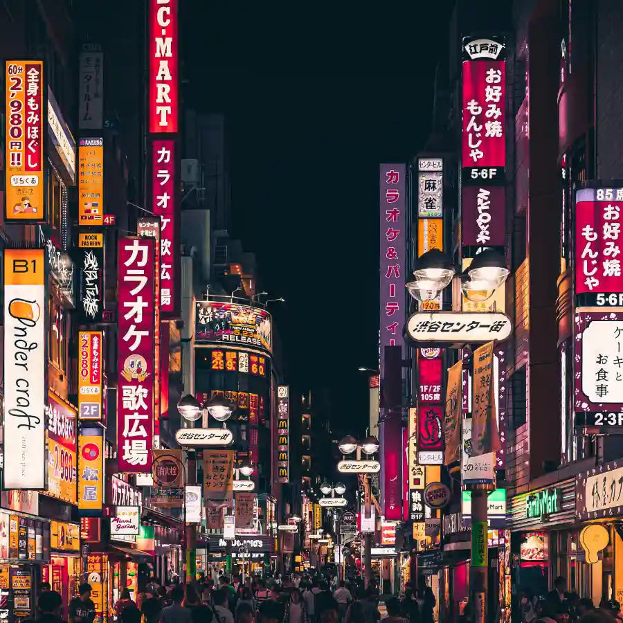 Tokyo di notte con luci e insegne nel quartiere moderno giapponese