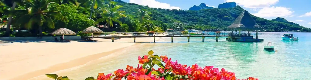 Laguna tropicale a Bora Bora con spiaggia, fiori e montagne verdi