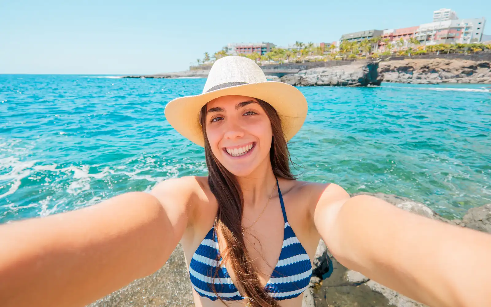 Viaggiatrice scatta una foto durante una vacanza al mare utilizzando una eSIM internazionale