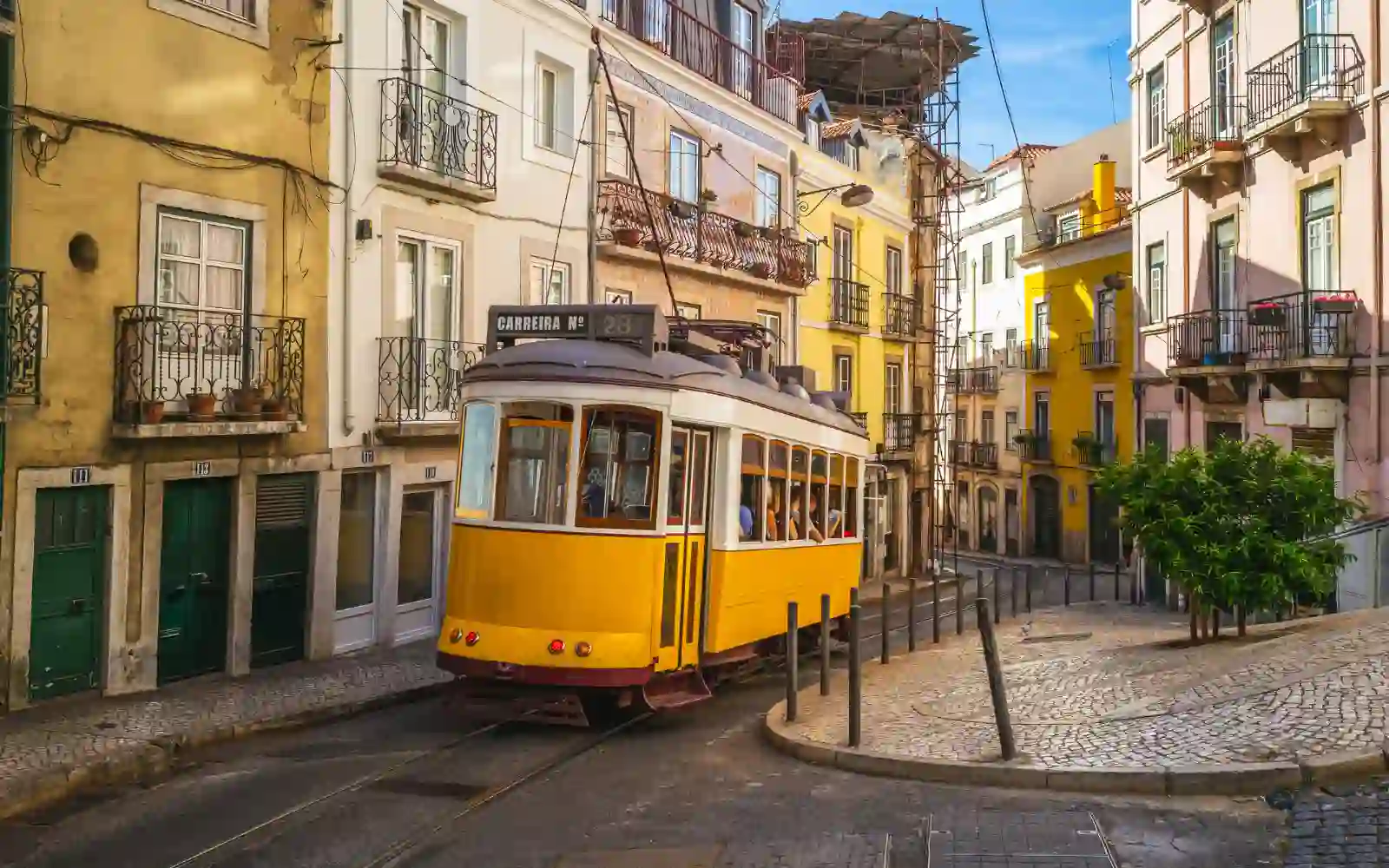 Tram giallo percorre una strada storica nel centro di Lisbona