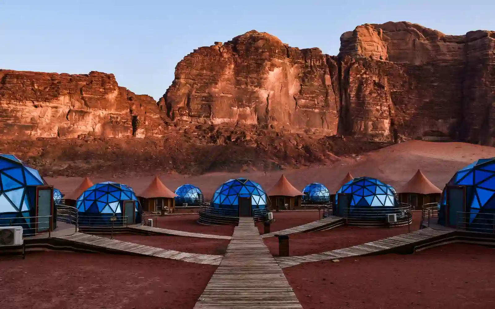 Campo tendato nel deserto dell'Oman circondato da imponenti montagne rocciose