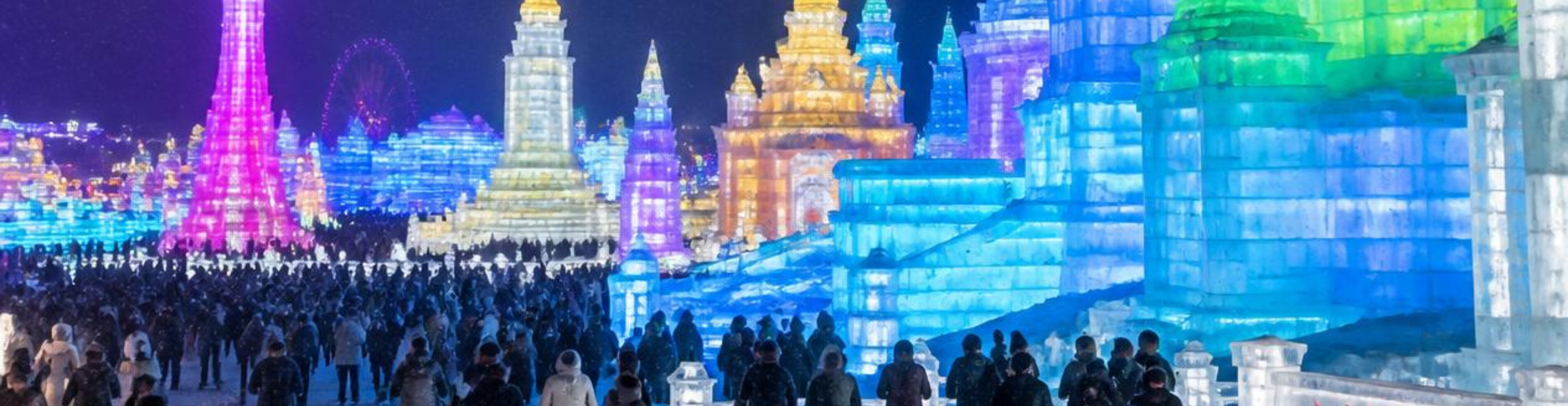 Grande castello di ghiaccio illuminato sotto il cielo notturno del Festival di Harbin.