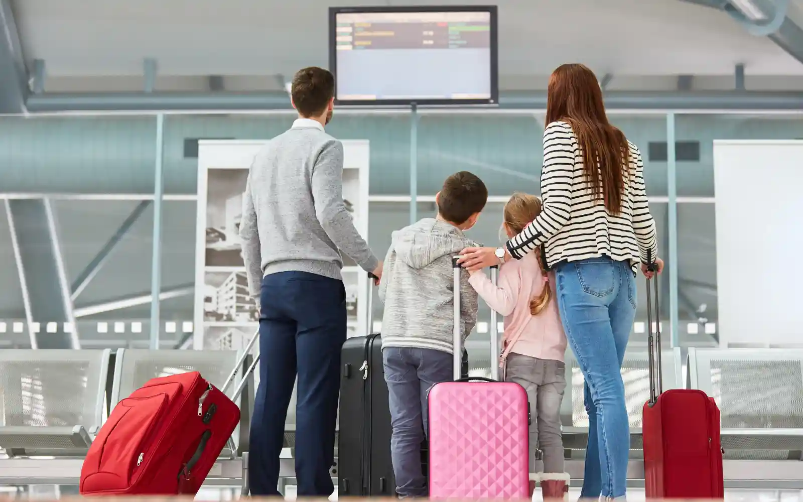 Famiglia in aeroporto pronta a partire con le valigie