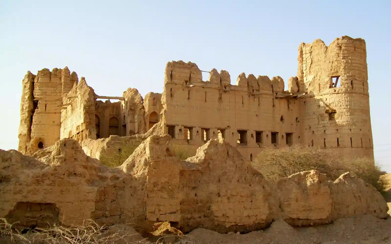 Antica fortezza in terra cruda circondata dal paesaggio arido dell'Oman