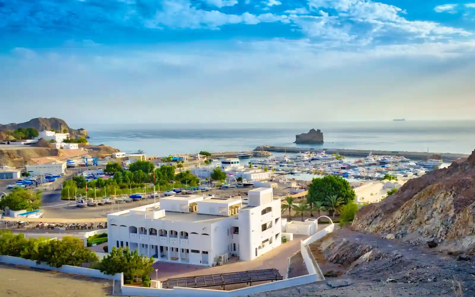 Panorama del porto di Muscat tra mare, montagne e architettura tradizionale dell'Oman