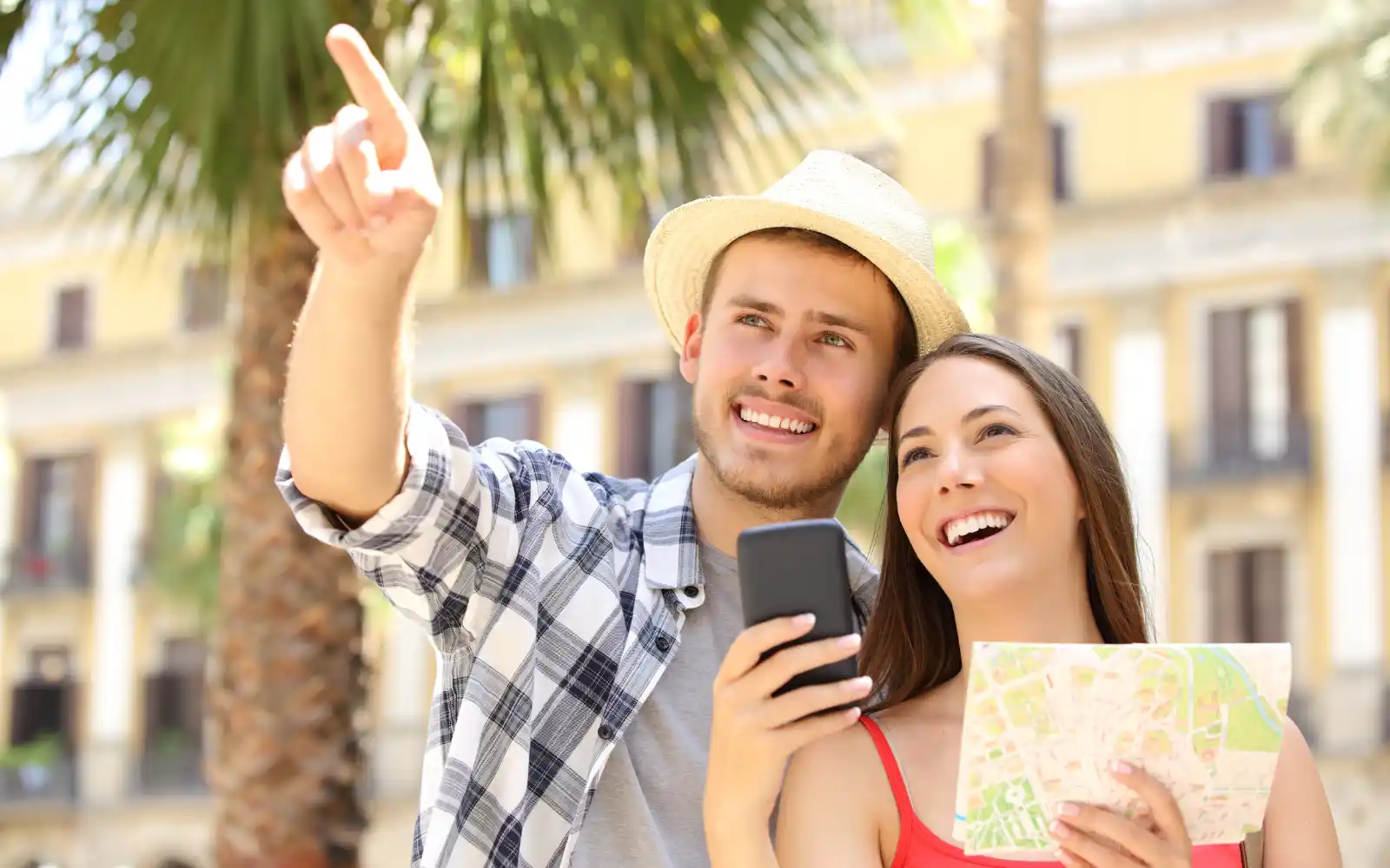 Coppia pianifica una vacanza consultando mappa e smartphone prima della partenza