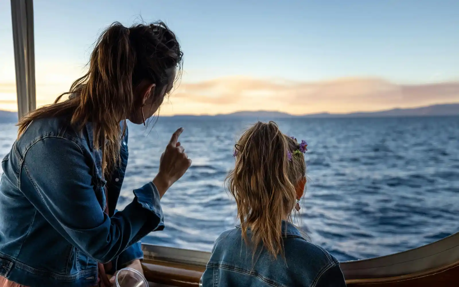 Madre e bambina osservano il mare dal finestrino durante una vacanza in crociera