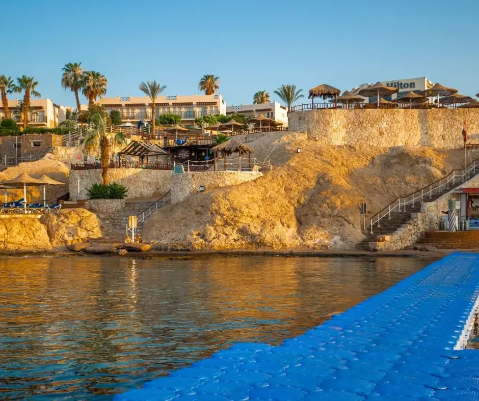 DoubleTree by Hilton Sharm fronte mare Resort affacciato sul mare con edifici terrazzati, palme e accesso alla costa.