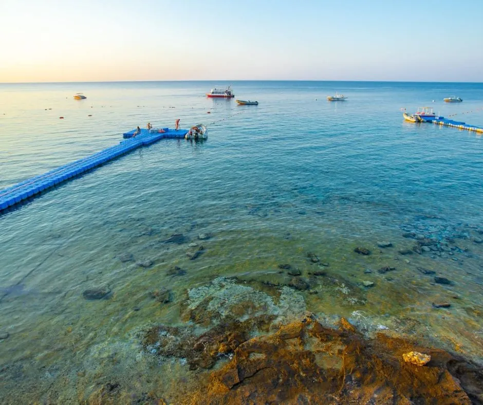 Mare di Sharks Bay a Sharm el-Sheikh Mare limpido con fondale roccioso visibile e pontile galleggiante nella zona di Sharks Bay.
