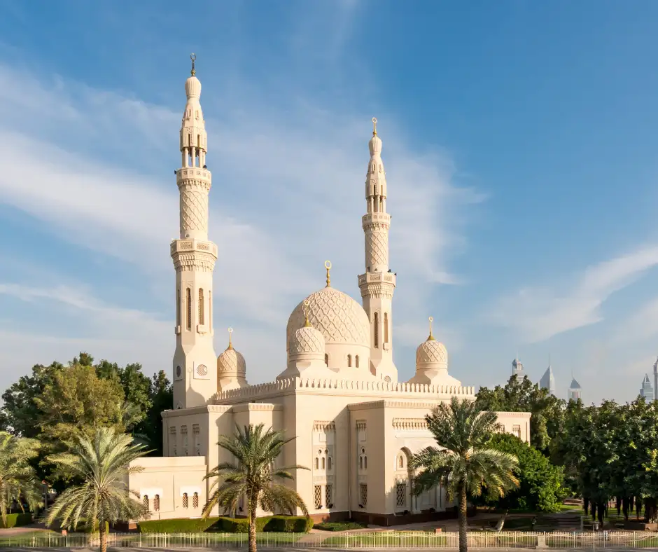 Moschea di Jumeirah โ Dubai Moschea di Jumeirah a Dubai con cupole, due minareti e palme sotto il cielo azzurro.