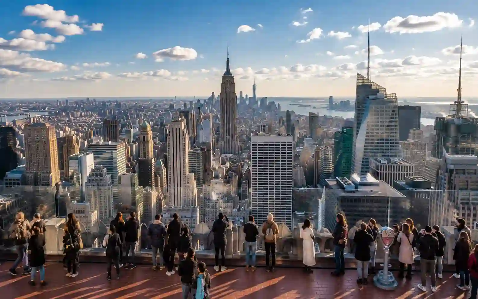 Panorama di Manhattan dall’alto con l’Empire State Building e visitatori su una terrazza panoramica