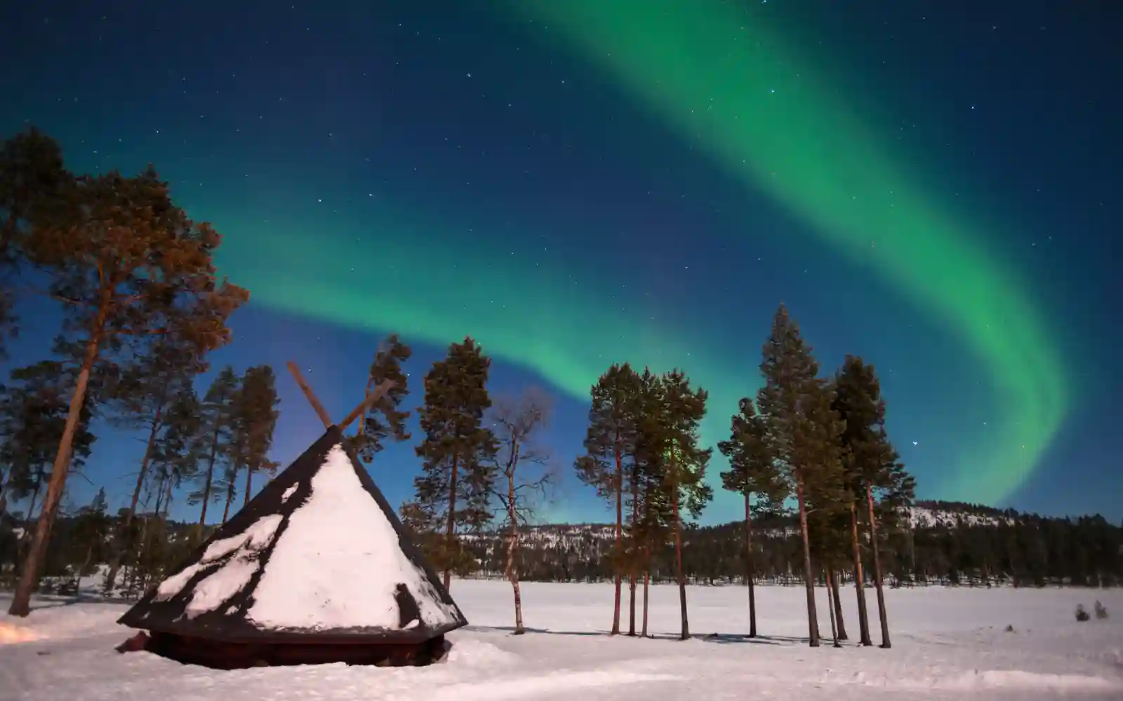 Aurora boreale sopra un paesaggio innevato durante una notte invernale