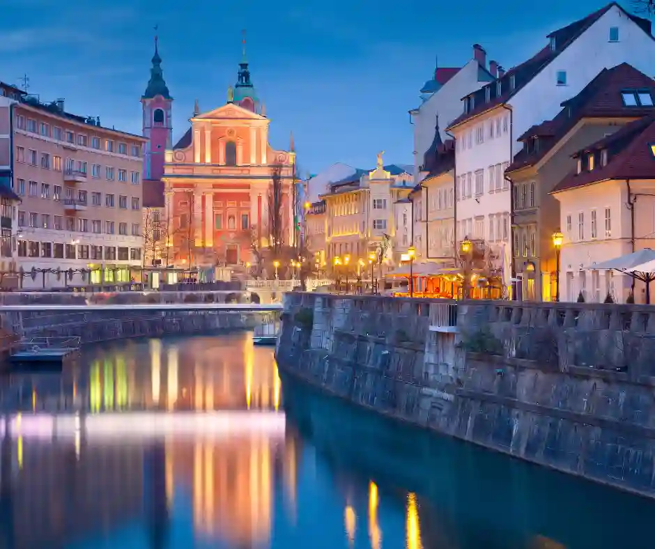 Lubiana lungo il fiume Ljubljanica Centro storico di Lubiana illuminato lungo il fiume Ljubljanica con la Chiesa Francescana sullo sfondo.