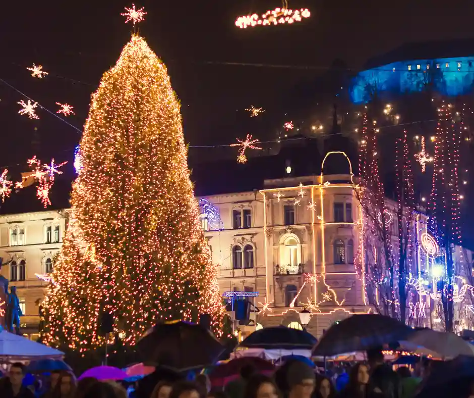 Natale a Lubiana Grande albero di Natale e luminarie nel centro di Lubiana con il castello illuminato sullo sfondo.