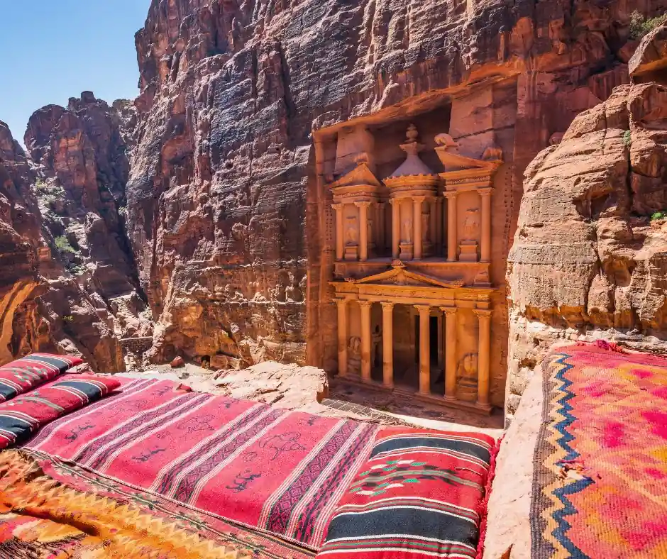 Pacchetto viaggio Giordania – Panorama sul Tesoro di Petra Vista panoramica sul Tesoro di Petra tra rocce rosse e tappeti tradizionali