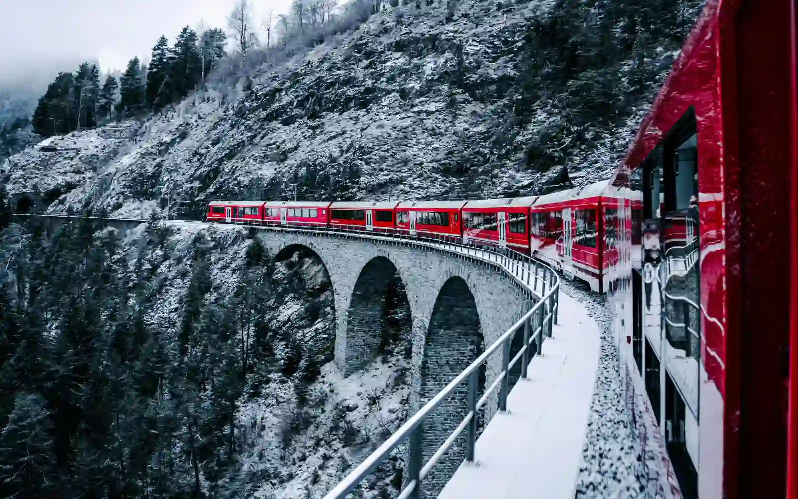 Treno panoramico che attraversa un paesaggio innevato in inverno