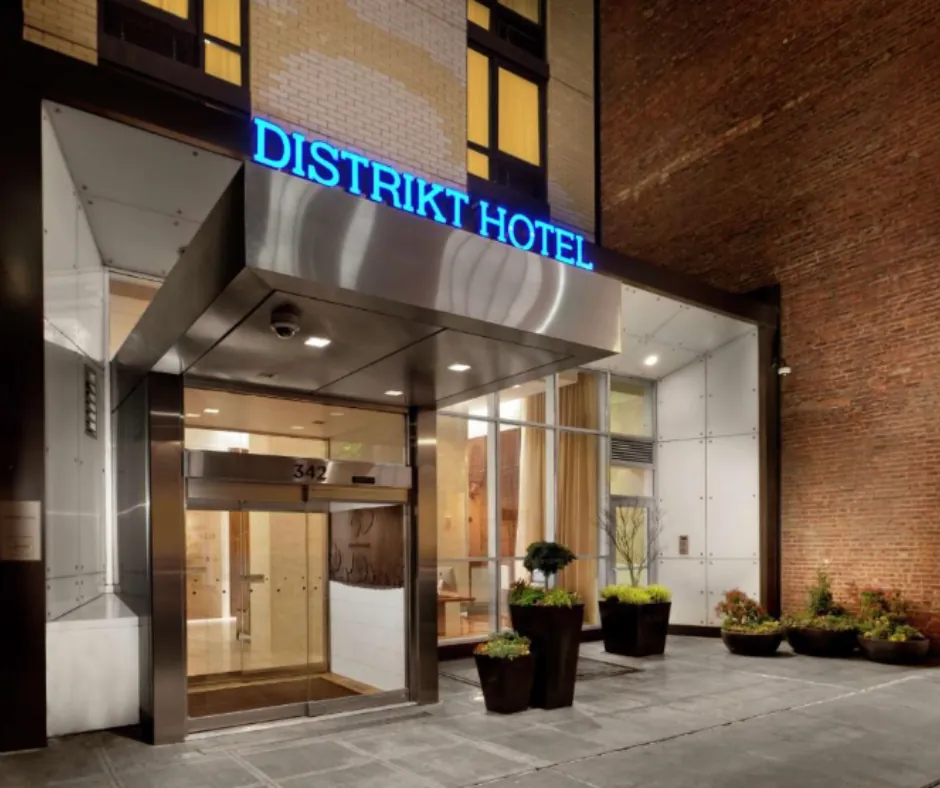 Distrikt Hotel New York – Ingresso Ingresso del Distrikt Hotel a New York, con insegna illuminata e porte vetrate.