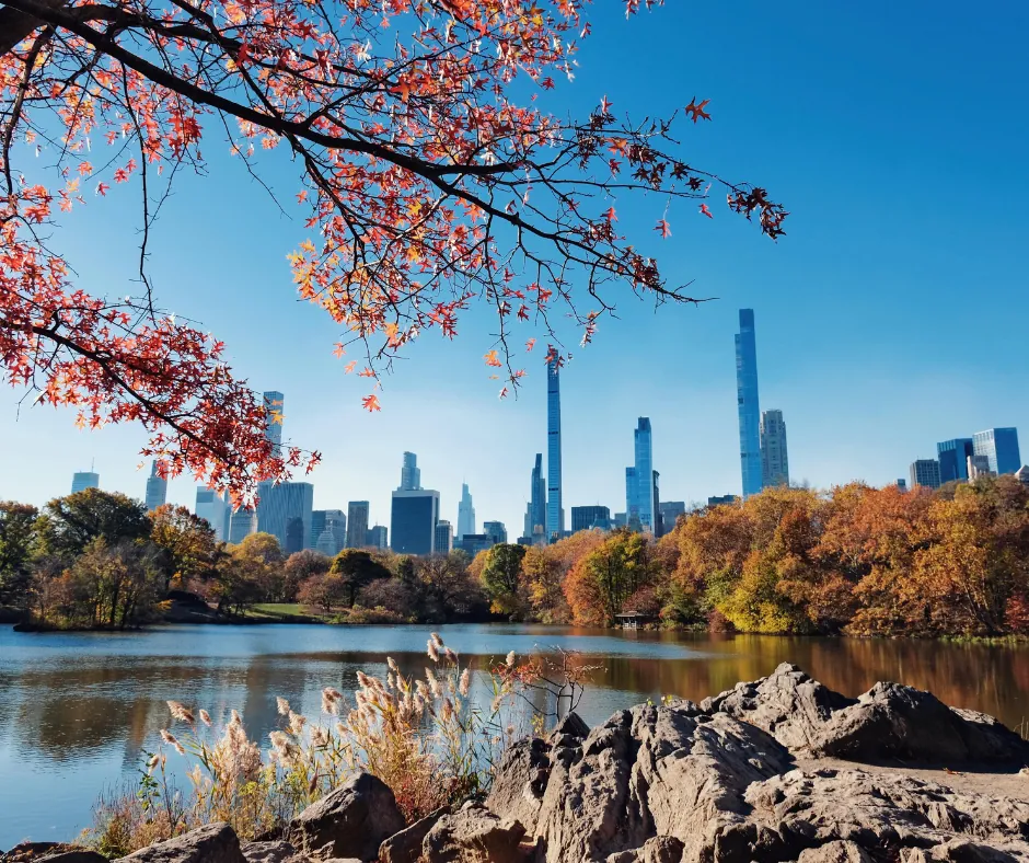 New York – Central Park Lago di Central Park con alberi autunnali e grattacieli sullo sfondo.