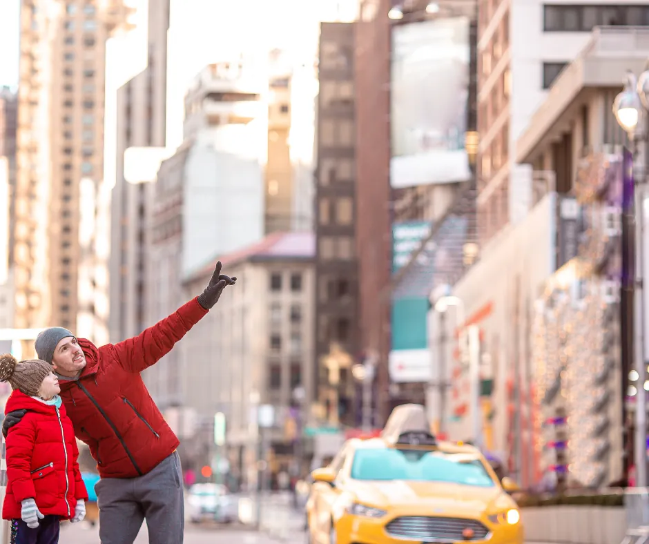 New York – Tra le strade di Manhattan Due persone con giacche rosse in una strada di New York, vicino a un taxi giallo.