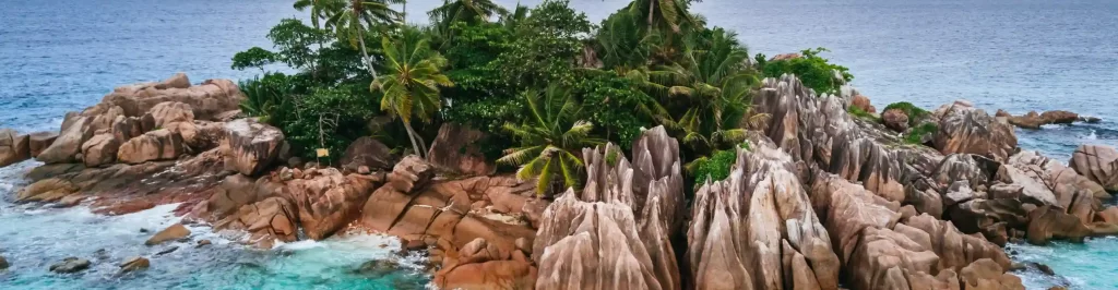 Vista aerea dell'isolotto di St. Pierre alle Seychelles con scogliere di granito e vegetazione tropicale circondate da mare turchese.